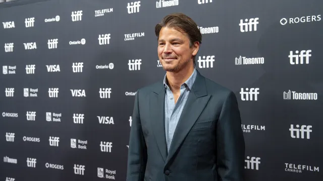 Josh Hartnett in a dark suit and open-collared shirt on the red carpet at the Toronto International Film Festival