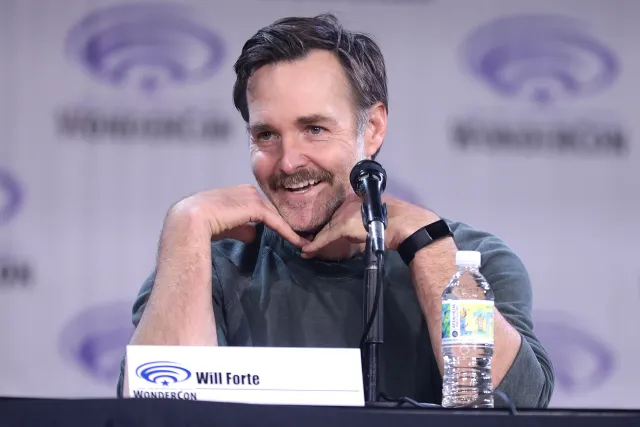 Will Forte speaking into a microphone on a convention panel