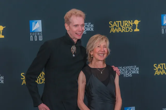 Lin Shaye in a black dress beside Doug Jones at the Saturn Awards