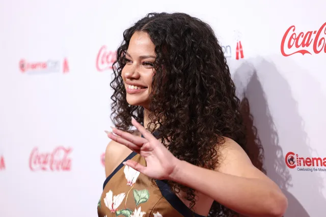 Catherine Laga'aia smiling and waving on the red carpet at CinemaCon in Las Vegas