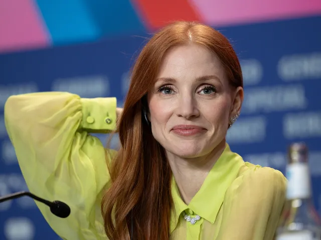 Jessica Chastain smiling at a press conference, wearing a lime-green blouse