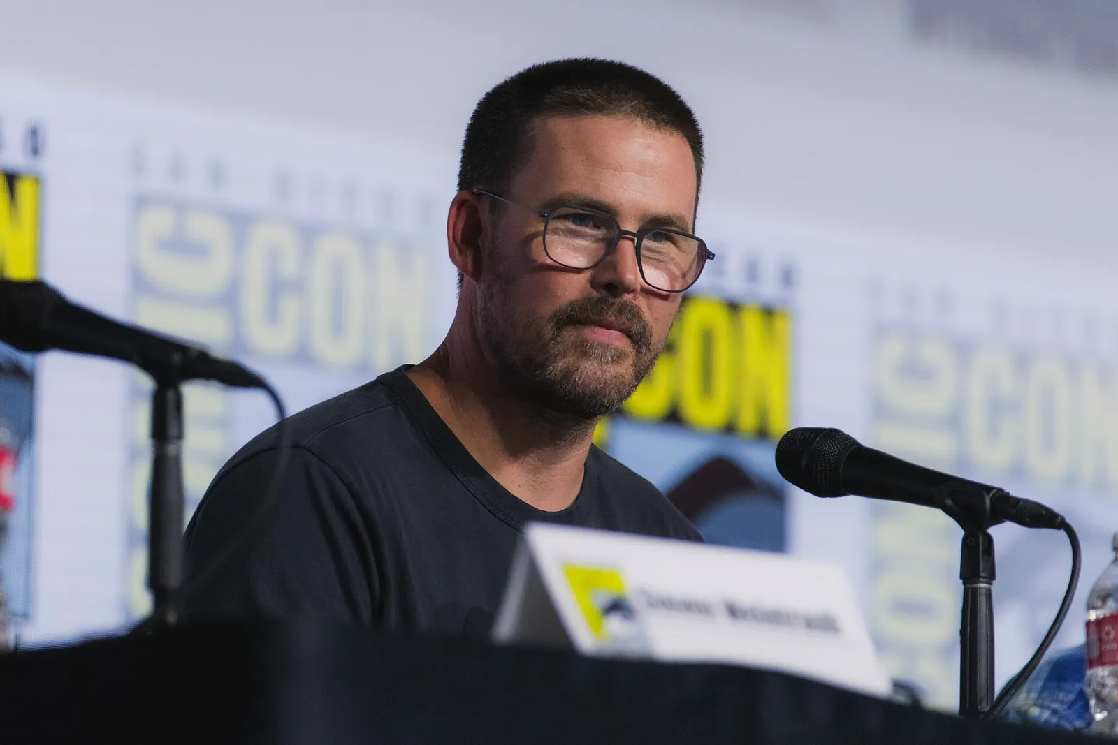 Director Zach Cregger, wearing glasses, seated at a microphone on a San Diego Comic-Con panel