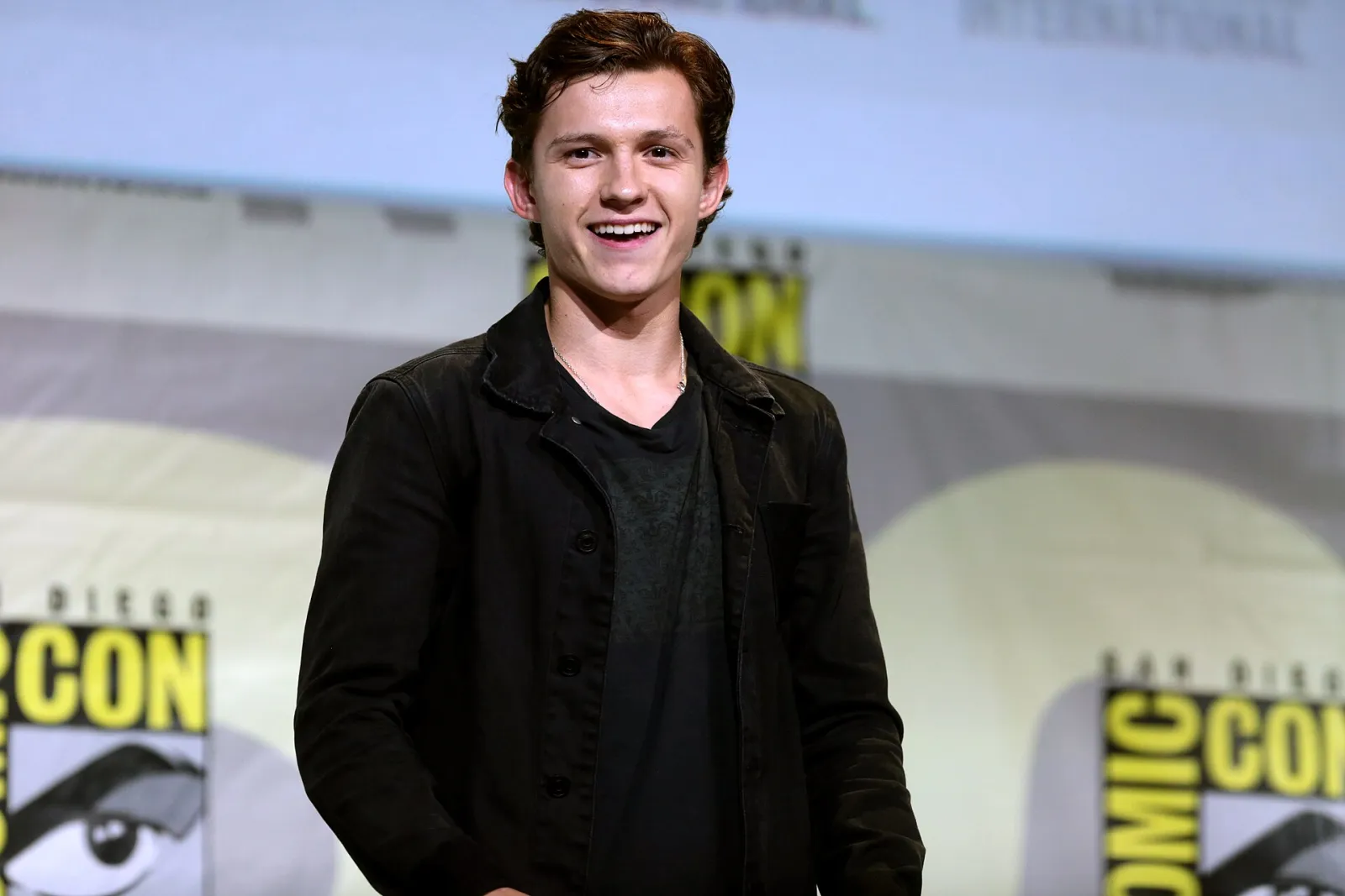 Tom Holland smiling on stage at San Diego Comic-Con