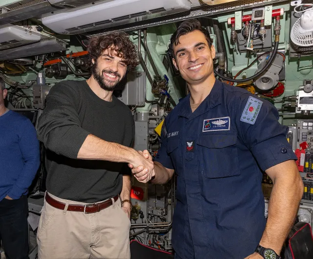 Noah Centineo shaking hands with a US Navy sailor during a visit to Naval Station Norfolk
